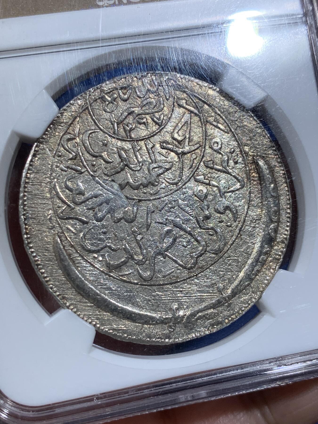 《竞宝斋》第411场 周日，周一，周二，3场连拍 （全场包邮） NGC MS62 也门AH1374(1955)弯刀克朗大银币  少见网红品种，有分难得！该系列很多都是以“大奶妈”等贸易银币为币坯，后期压制的；这枚可以清晰地看见弯刀的刀刃部分有原币坯的细节痕迹，非常值得玩味