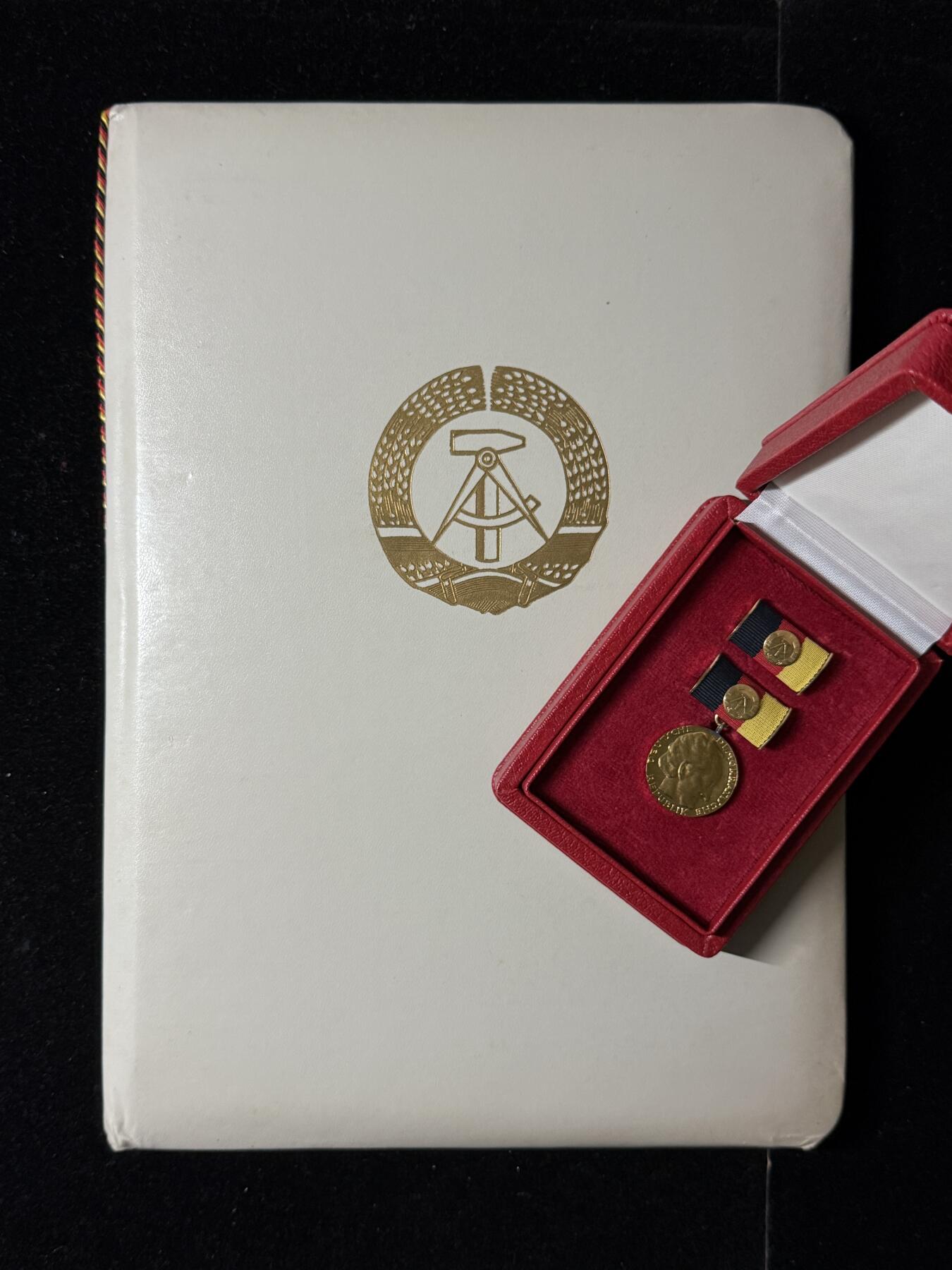 戎马世界章牌大赏第103期 东德歌德奖金（国家奖金）证章，带大证书，授予Hans Bekurts，得主介绍见最后一图，证书尺寸巨大仿皮非常厚实，实发非常少见，该证书为两德统一前最后一次授予的国家奖金，见证了东德的落幕