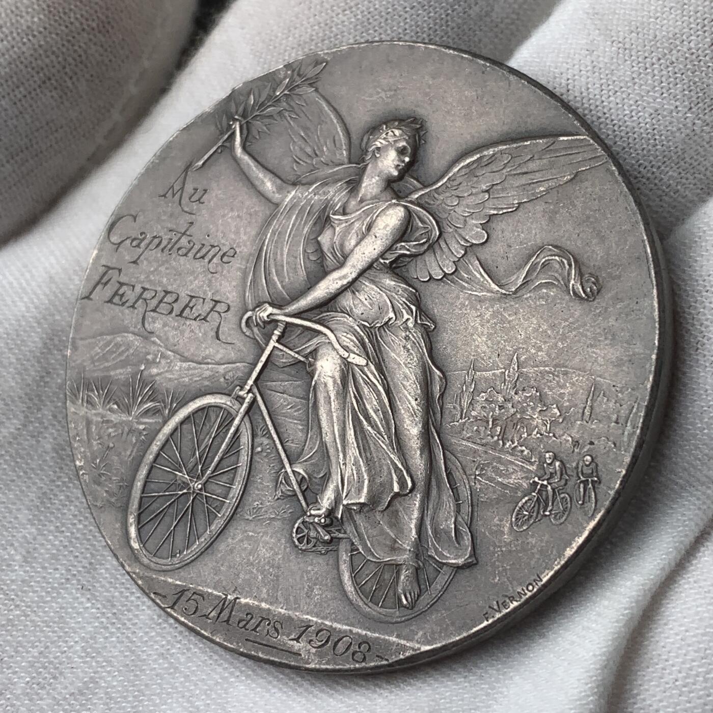 掌中浮雕-藏着的欧洲第034场 1908年法国自行车女神镀银铜章，50mm，64.8g，此章实发给欧洲航空先驱费贝尔上尉，他与飞机发明者莱特兄弟熟识。边有划痕