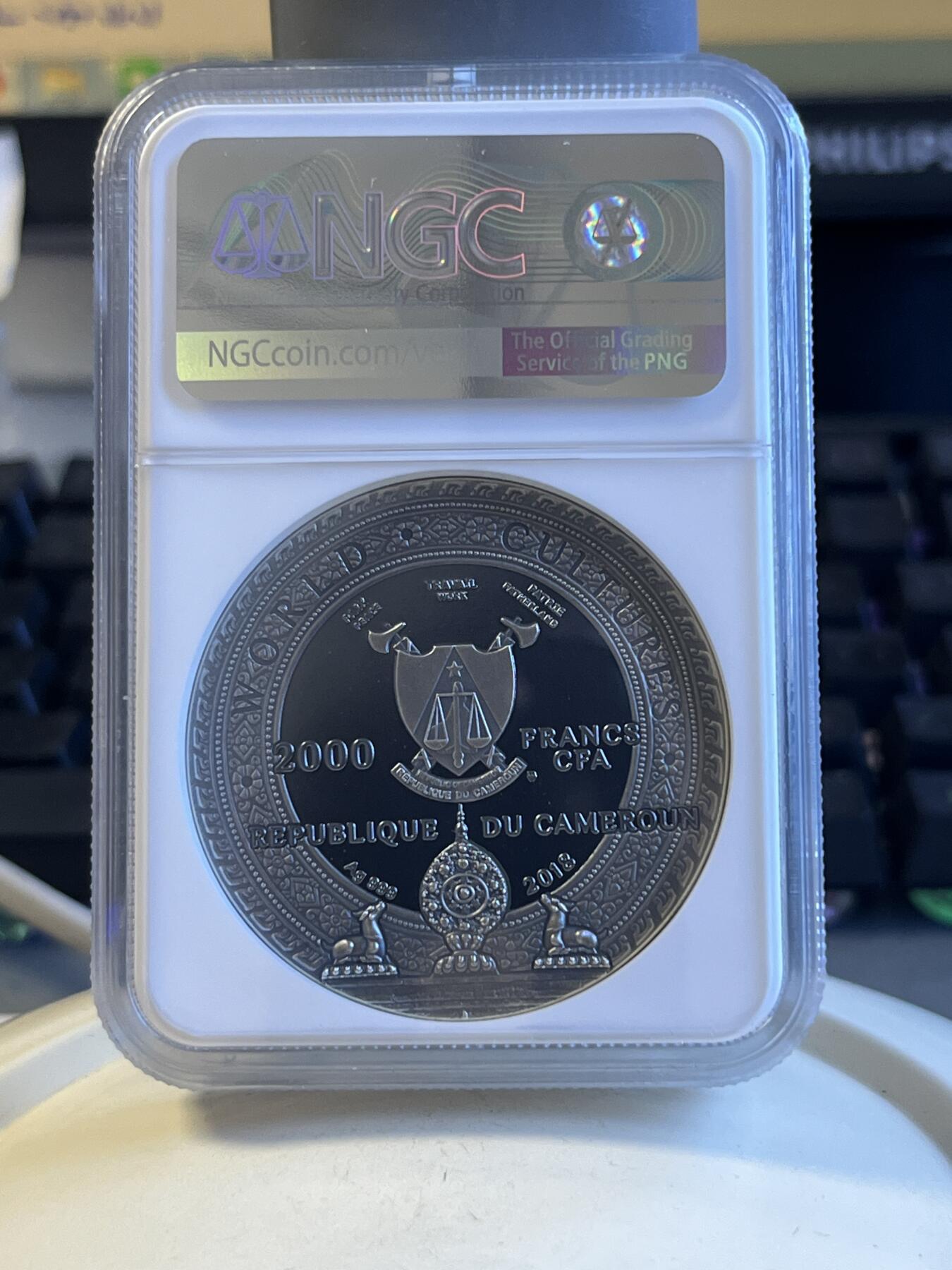第172期拍卖【长期征集拍品】 喀麦隆2018世界文化系列1卡帕头骨2盎司高浮雕镶嵌银币NGC-PF69原盒证书，999银，发行500枚