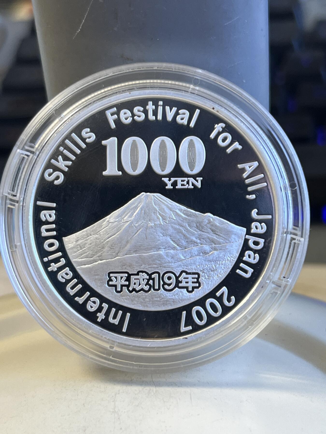 第173期拍卖【长期征集拍品】 日本2007年1千日元精制彩色银币 国际技能节 31.1克 999银，发行量：8万枚，
