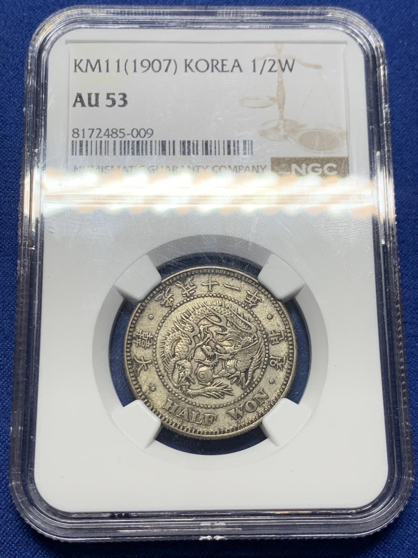 《竞宝斋》第415场 周日，周一，2场连拍 （全场包邮） NGC AU53  朝鲜1907年光武十一年半圆 小版稀少年份 黑金自然老彩，正面蟠龙戏珠图，龙身盘踞如环，背面上方为“李花章”（五瓣木槿花），下方交叉的桔梗花（左）与李花（右），低评状态，舒服怡人