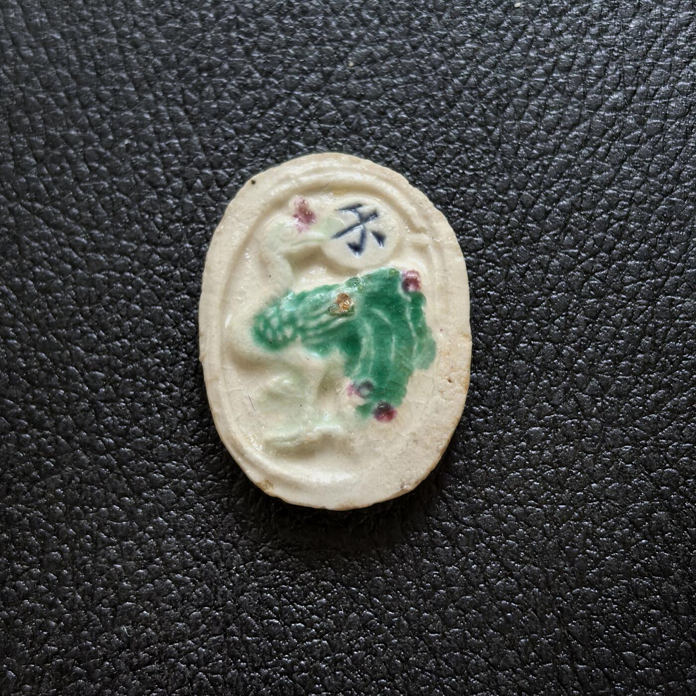 博洋堂暹罗瓷币专场拍卖暨第138期（全场包邮） 萬金/孔雀-钱 写实且多色的描绘了一直栩栩如生的孔雀，既是防伪也表现了极高的艺术性，上到孔雀眼睛的刻画下到羽翎的点色都非常完美，万金的外围还装饰以兑子纹，釉色鲜亮的极品。