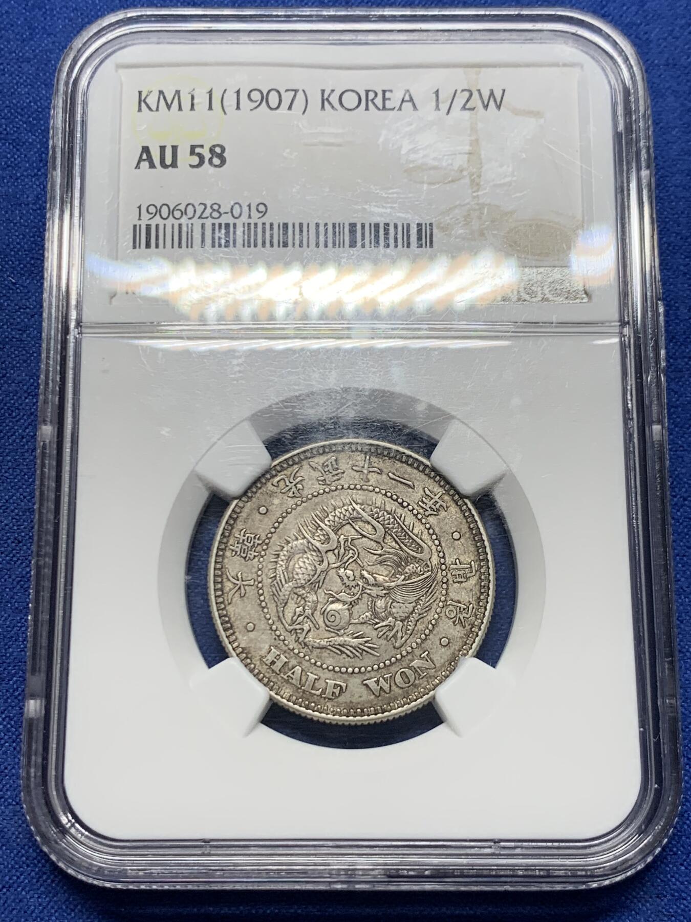 《竞宝斋》第417场 周日，周一，2场连拍 （全场包邮） NGC AU58  朝鲜1907年光武十一年半圆 小版稀少年份 百年原味通体自然老彩，正面蟠龙戏珠图，龙身盘踞如环，背面上方为“李花章”（五瓣木槿花），下方交叉的桔梗花（左）与李花（右），低评UNC状态 舒服怡人