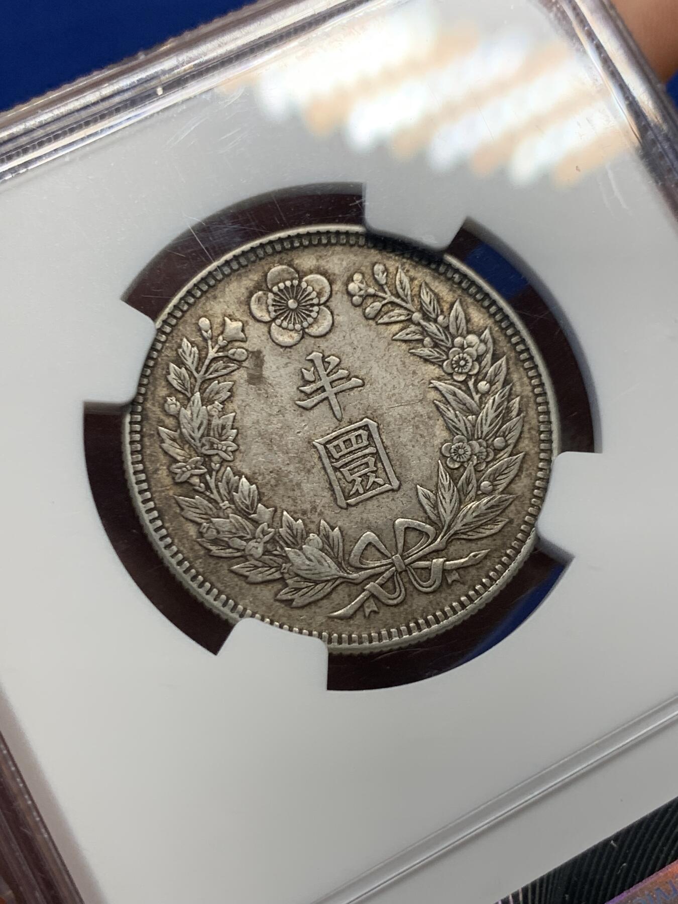 《竞宝斋》第417场 周日，周一，2场连拍 （全场包邮） NGC AU58  朝鲜1907年光武十一年半圆 小版稀少年份 百年原味通体自然老彩，正面蟠龙戏珠图，龙身盘踞如环，背面上方为“李花章”（五瓣木槿花），下方交叉的桔梗花（左）与李花（右），低评UNC状态 舒服怡人