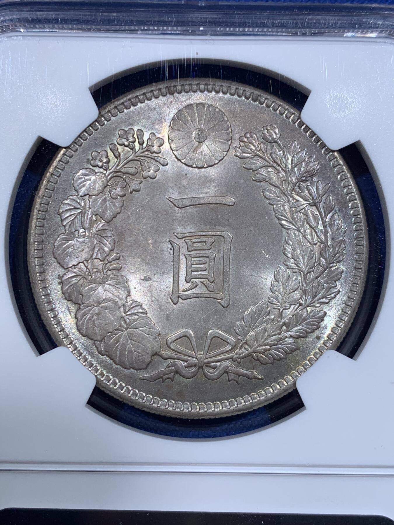 《竞宝斋》第417场 周日，周一，2场连拍 （全场包邮） NGC MS64 日本1905年明治三十八年一圆 日俄战争年份 整体淡灰色包浆 正面四周有很明显很均匀的环彩 宛若白龙被关在笼子里 甚是有趣 背面四周则有彩虹包浆 64分再搭配上此等包浆足以入藏