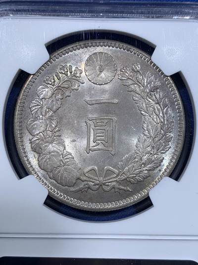 《竞宝斋》第417场 周日，周一，2场连拍 （全场包邮） NGC MS64 日本1905年明治三十八年一圆 日俄战争年份 整体淡灰色包浆 正面四周有很明显很均匀的环彩 宛若白龙被关在笼子里 甚是有趣 背面四周则有彩虹包浆 64分再搭配上此等包浆足以入藏