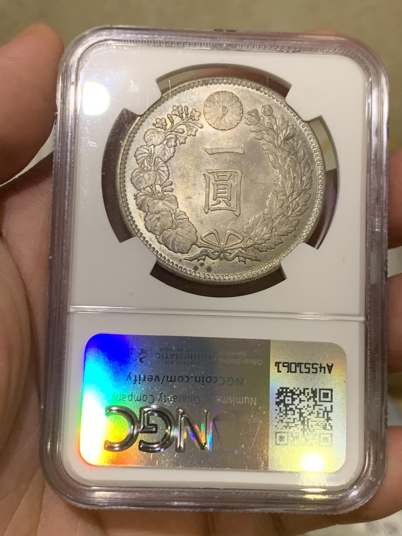 《竞宝斋》第417场 周日，周一，2场连拍 （全场包邮） NGC MS64 日本1905年明治三十八年一圆 日俄战争年份 整体淡灰色包浆 正面四周有很明显很均匀的环彩 宛若白龙被关在笼子里 甚是有趣 背面四周则有彩虹包浆 64分再搭配上此等包浆足以入藏