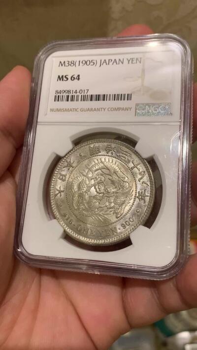 《竞宝斋》第417场 周日，周一，2场连拍 （全场包邮） NGC MS64 日本1905年明治三十八年一圆 日俄战争年份 整体淡灰色包浆 正面四周有很明显很均匀的环彩 宛若白龙被关在笼子里 甚是有趣 背面四周则有彩虹包浆 64分再搭配上此等包浆足以入藏