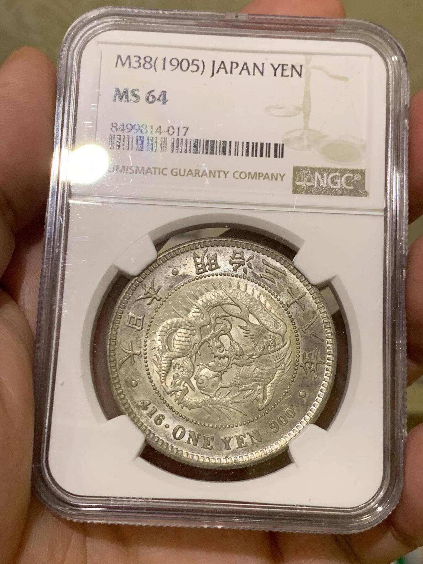 《竞宝斋》第417场 周日，周一，2场连拍 （全场包邮） NGC MS64 日本1905年明治三十八年一圆 日俄战争年份 整体淡灰色包浆 正面四周有很明显很均匀的环彩 宛若白龙被关在笼子里 甚是有趣 背面四周则有彩虹包浆 64分再搭配上此等包浆足以入藏