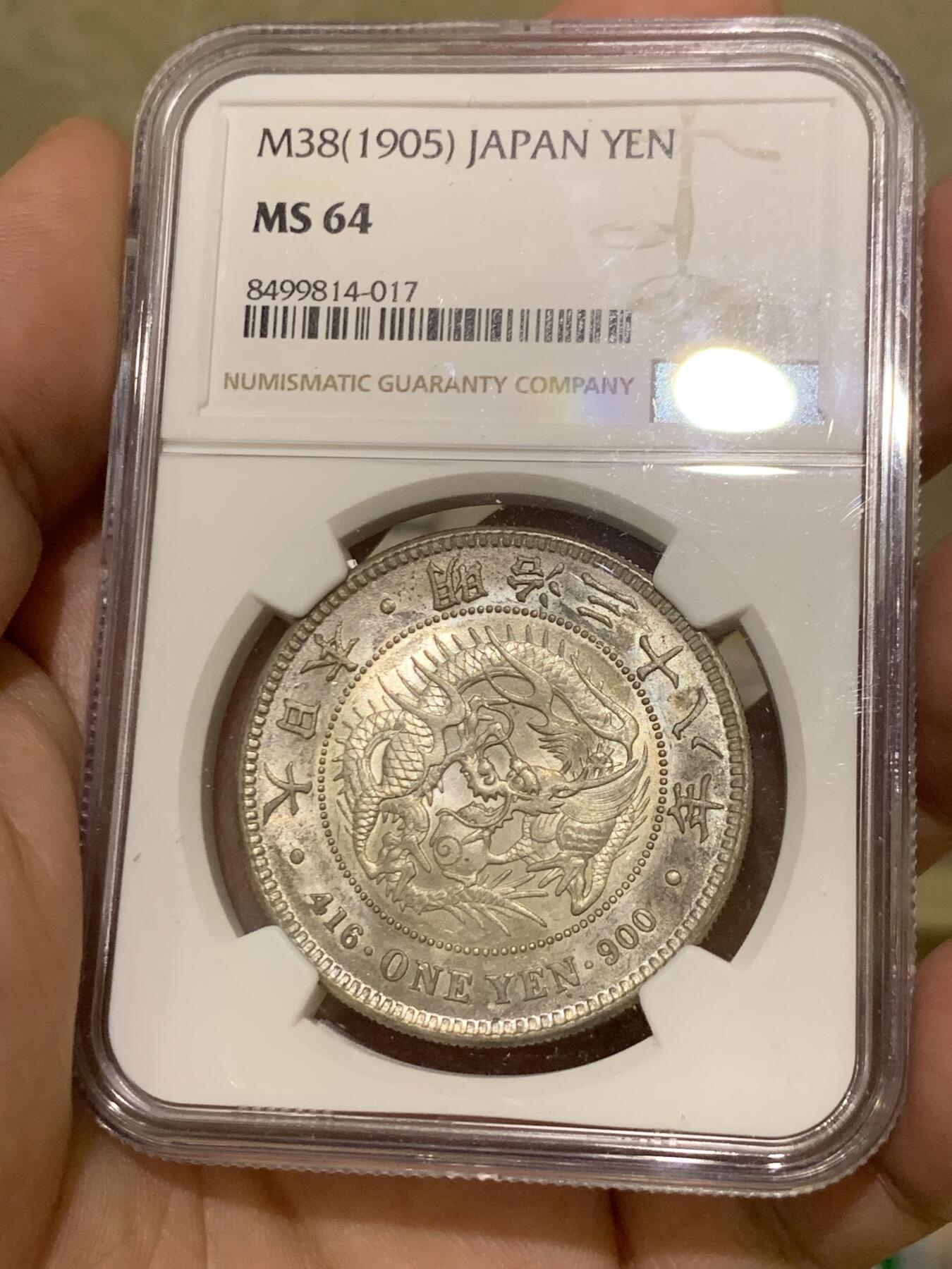 《竞宝斋》第417场 周日，周一，2场连拍 （全场包邮） NGC MS64 日本1905年明治三十八年一圆 日俄战争年份 整体淡灰色包浆 正面四周有很明显很均匀的环彩 宛若白龙被关在笼子里 甚是有趣 背面四周则有彩虹包浆 64分再搭配上此等包浆足以入藏