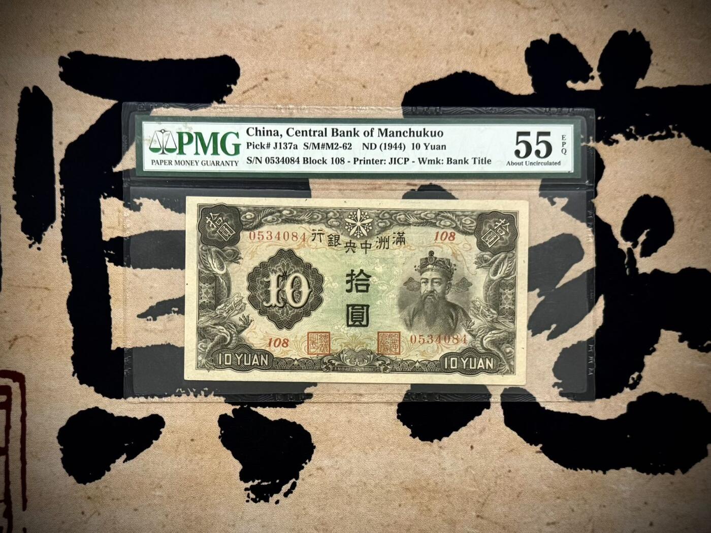 （自动截拍）PMG评级民国纸币专拍第20250911期，全场包邮 【乾奕收藏】出民国33年1944年满洲中央银行拾圆，财神赵公明图案，美国PMG55E