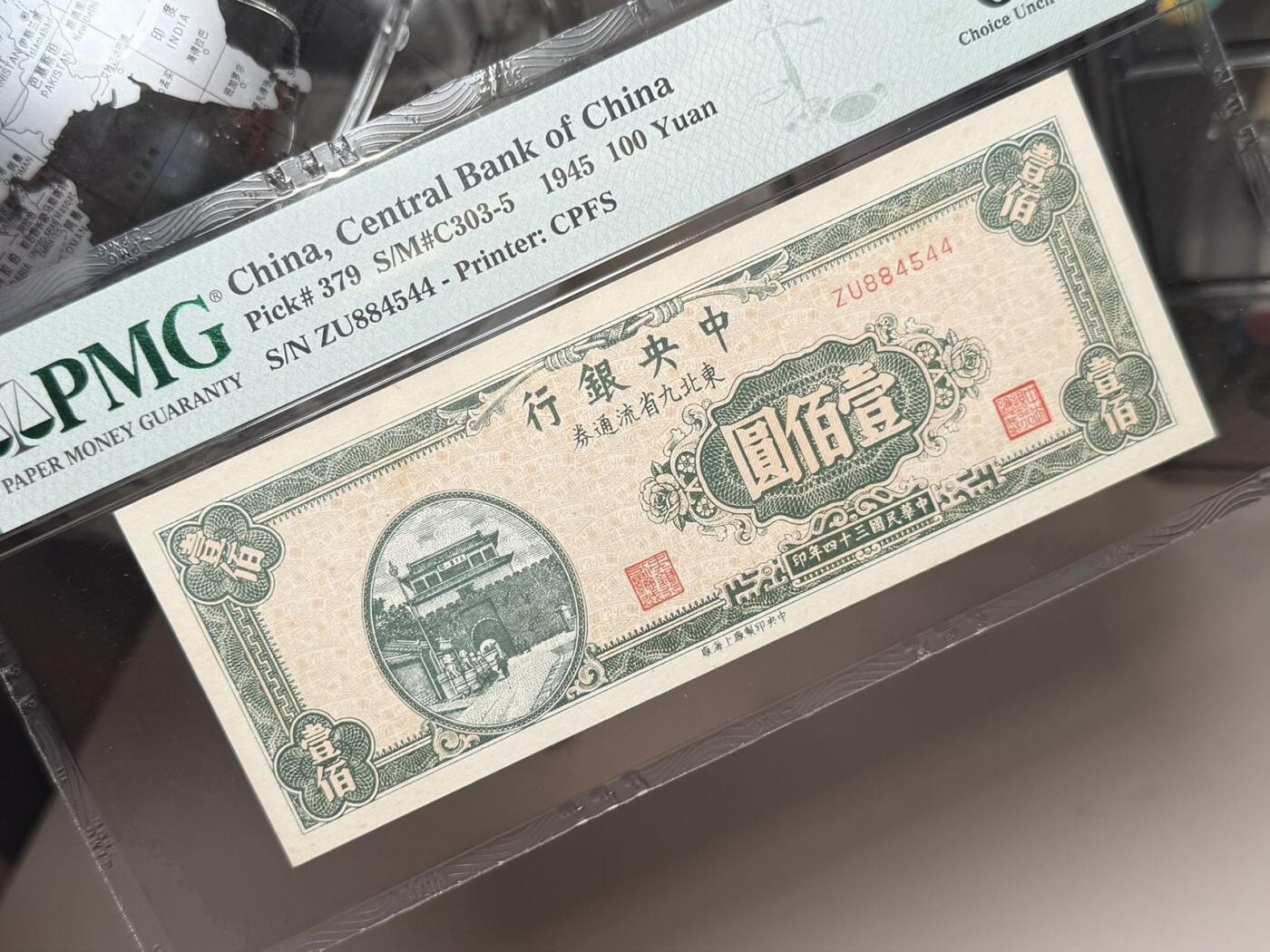 【乾奕收藏】出民国34年1945年中央银行东北九省流通券壹佰圆，458数三人三组合靓号，PMG64，稀少热门品种，民国纸币经过80年能保存如此品相实属难得，喜欢的老板不要错过，评级币一切以分数为准，售出非假不退