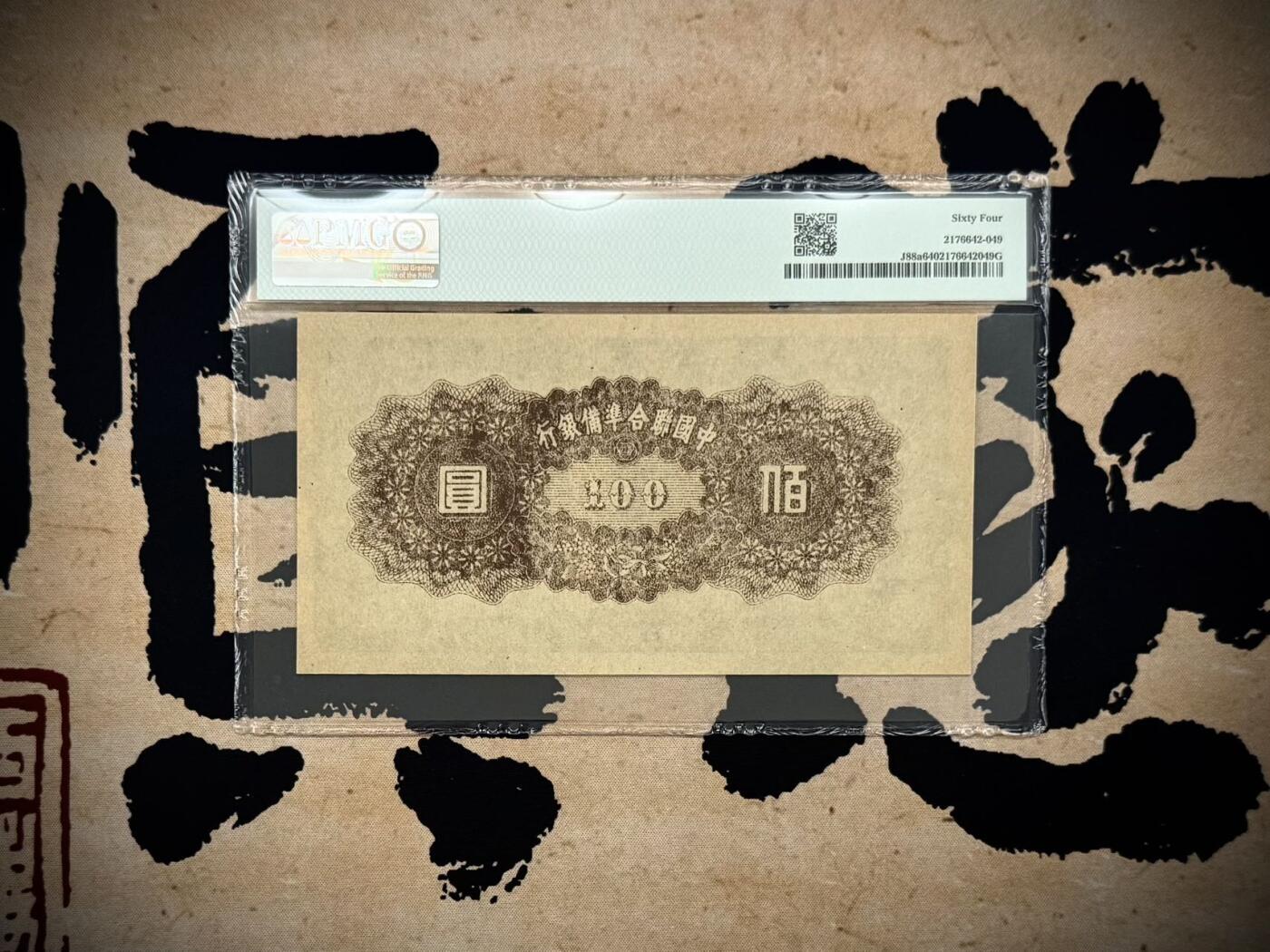  【乾奕收藏】出民国34年1945年中国联合准备银行壹百圆，右皇帝像，美国PMG64，民国纸币经过80年能保存如此品相实属难得，喜欢的老板不要错过，评级币一切以分数为准，售出非假不退