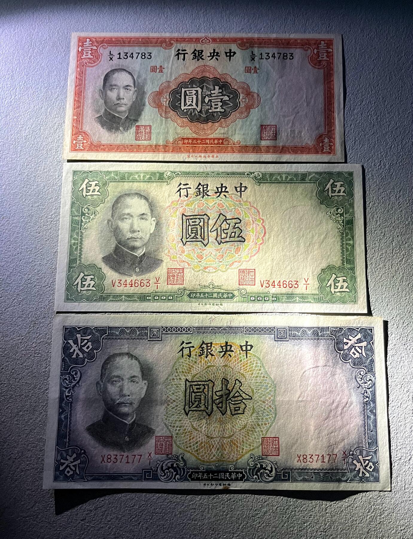 日本战争债券、英国伊二女王末版纸币套、哈萨克斯坦2万坚戈纪念钞、民国钞、台湾经济振兴券，台湾原住民系列套币/生肖银币，新疆喀什饷银五钱，康熙/光绪铜钱，哈萨克斯坦精制纪念银币，荷属东印度爪哇岛小铜块。彼得堡世界钱币勋章拍卖第133期 民国二十五年-中央银行1936年壹圆、伍圆、拾圆纸币3枚套，华德路、德纳罗版