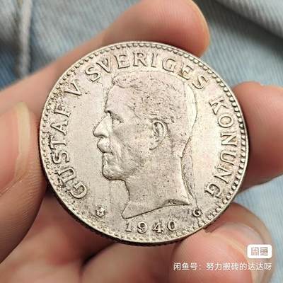 1940年瑞典古斯塔夫五世2克朗银币。银币重15g，含银80%。正面是瑞典国王古斯塔夫五世，背面是瑞典的皇家盾徽上面是皇冠，周围环绕着一圈是皇家勋章下面是2克朗面值。币面淡淡黄油彩包浆流通好品，菜鸟包邮售出不退不换。 - 1940年瑞典古斯塔夫五世2克朗银币。银币重15g，含银80%。正面是瑞典国王古斯塔夫五世，背面是瑞典的皇家盾徽上面是皇冠，周围环绕着一圈是皇家勋章下面是2克朗面值。币面淡淡黄油彩包浆流通好品，菜鸟包邮售出不退不换。