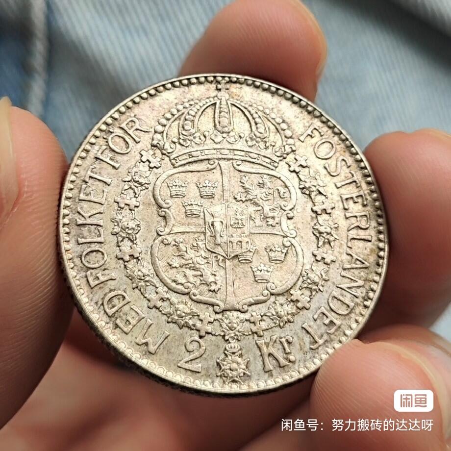1940年瑞典古斯塔夫五世2克朗银币。银币重15g，含银80%。正面是瑞典国王古斯塔夫五世，背面是瑞典的皇家盾徽上面是皇冠，周围环绕着一圈是皇家勋章下面是2克朗面值。币面淡淡黄油彩包浆流通好品，菜鸟包邮售出不退不换。