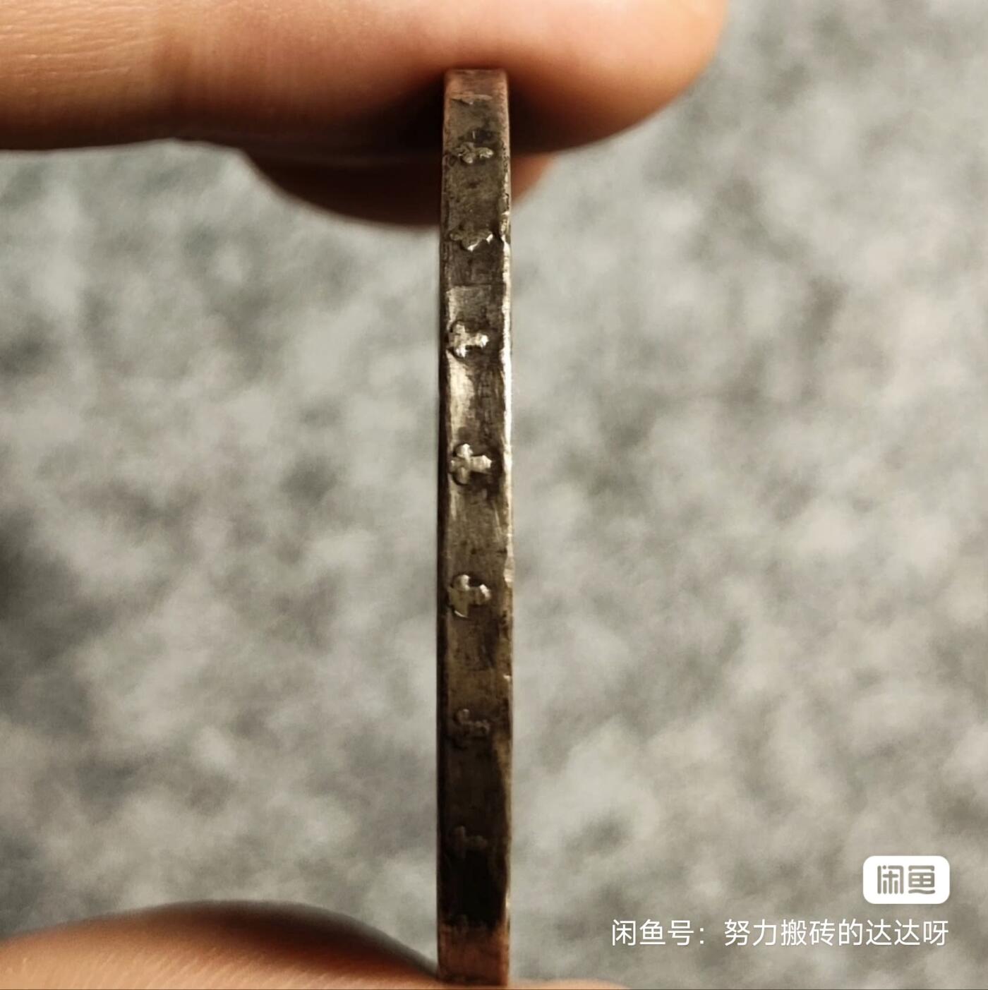 西班牙1877年阿方索十二世双柱5比塞塔银币 青年版少见。银币重25g，含银量90%。正面是西班牙国王阿方索十二世青年肖像，外环为拉丁文铭（阿方索十二世蒙神之恩）。背面图案是西班牙盾徽，盾徽中间椭圆内有三朵鸢尾花代表波旁王朝家族，椭圆旁有4栏分别代表四个王国。两侧各列一根海格力斯柱柱上卷轴绕裹，卷轴上有“海外有大陆”。头发细节全酱彩包浆，稀少版别流通好品。售出不退不换菜鸟包邮