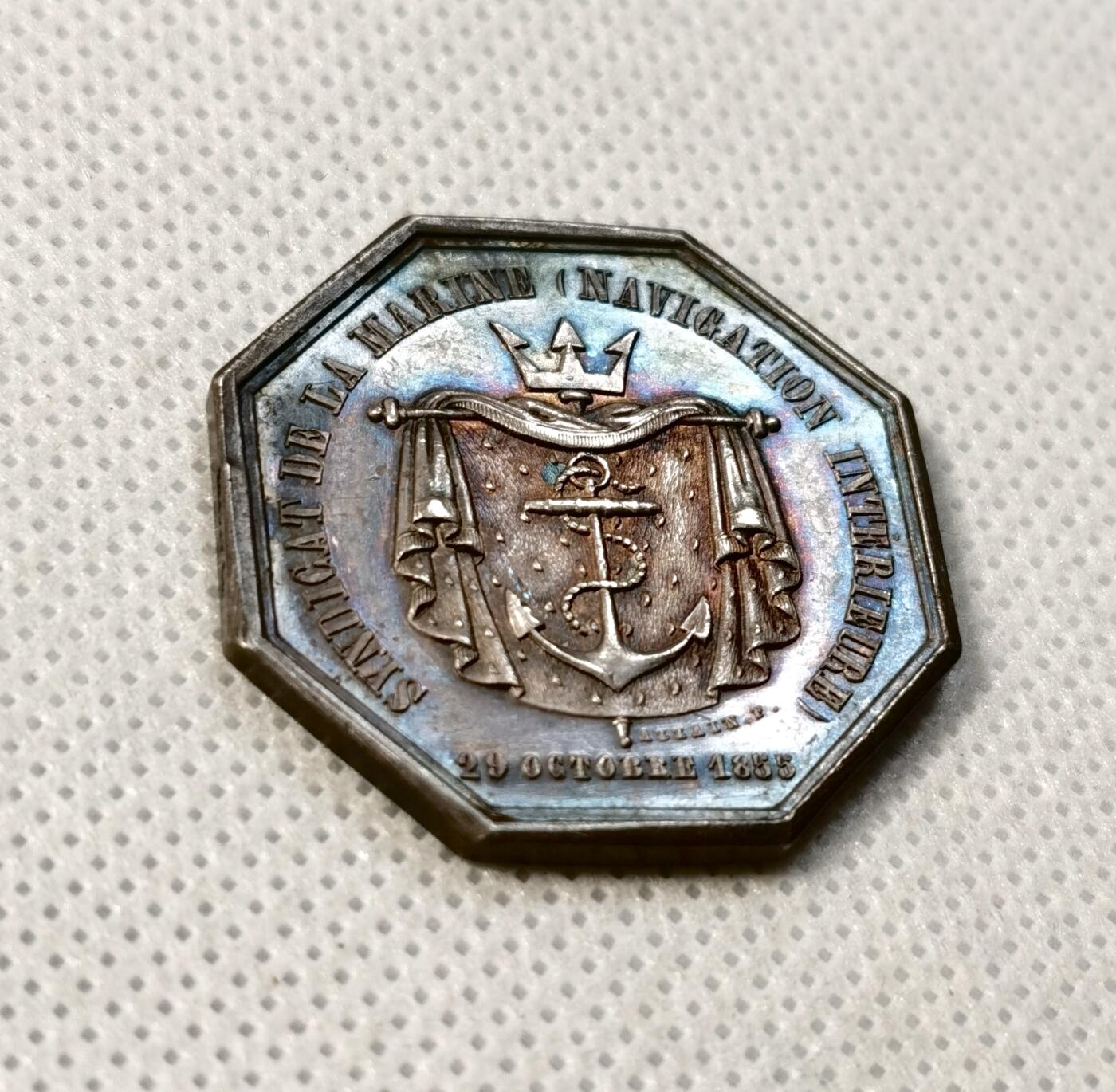 甄臻铺-世界币章拍卖（第35期），送拍享返佣金等优惠多多 法国航运业八角银章，1855年发行，对边30.8毫米，重15.2克。正面刻有船锚和皇冠图案，环绕帆布装饰，背面刻有