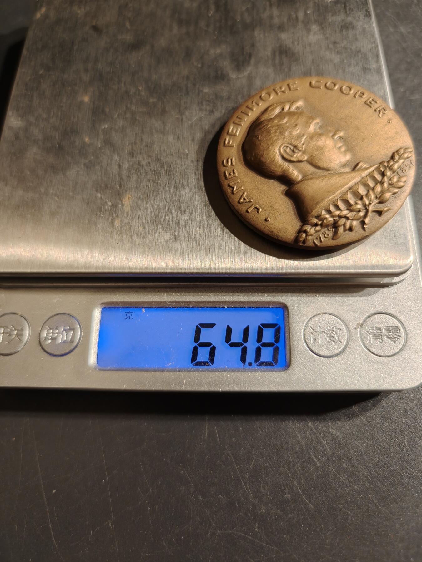 老王徽章第151期 美国纽约大学名人堂大铜章 直径43mm. 重量56.3g.     詹姆斯·费尼莫尔·库珀（1789-1851）是19世纪美国著名的浪漫主义小说家，以其边疆小说和海洋故事而闻名。