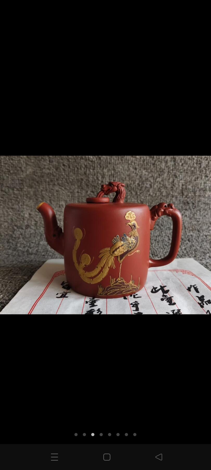 一厂徒工班，顾景舟辅导，徐汉棠制壶。壶身饰有金色凤凰等精美纹样，雅致又富有韵味。长14厘米、高10厘米，容量约280毫升，品茗、观赏、收藏皆宜，尽显宜兴紫砂工艺之美。