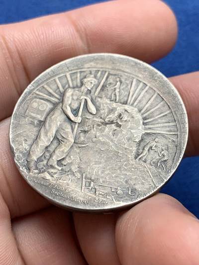 《竞宝斋》第423场 周日，周一，周二  3场连拍 （全场包邮） 法国鲁夫运河工程银质纪念章 22.9克 35.8mm  普通外拍 3200成交 正面：六边形盾徽上刻有年份1775， 图案区域标注1911-1916年及签名“GREGOIRE”；底部铭文“致鲁夫大型海上隧道的合作者与工人们”。背面：正在开凿的隧道中，一名工人倚靠镐头休息；底部铭文“长度7,200米 开口22米/断面300平方米”。 原盒  此章颁发给桥梁与公路总监察长克拉韦耶 