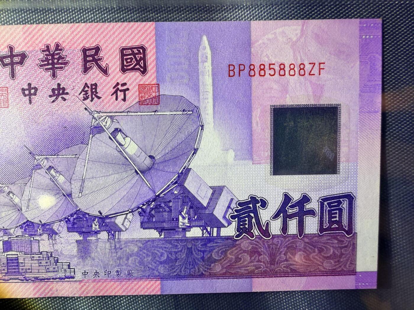 《外钞收藏家》第五百七十一期（国庆场第二场）（本平台长期征集拍品、欢迎藏友们联系合作） 新台币中华民国2000元纸币，全新 UNC 豹子BP885888，正面印有卫星天线和城市建筑图案，背面是雪山和鲑鱼图案，紫色调设计。
