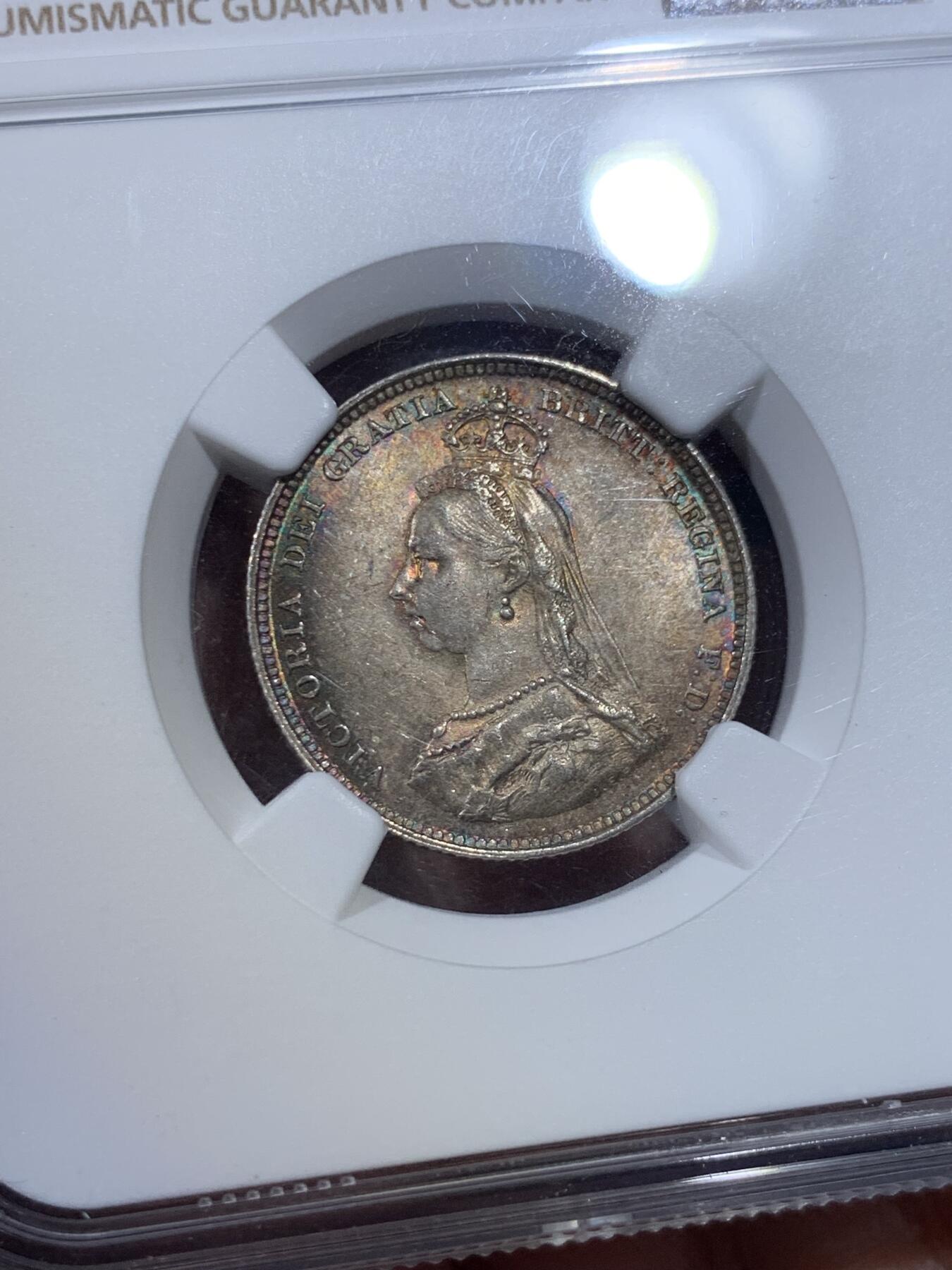《竞宝斋》第423场 周日，周一，周二  3场连拍 （全场包邮） NGC MS63 英国1887年 维多利亚女王1先令银币，欧洲老藏家百年收藏，长期储存形成的欧洲五彩包浆，双面色泽皆美丽动人，63分里的极品，姹紫嫣红。