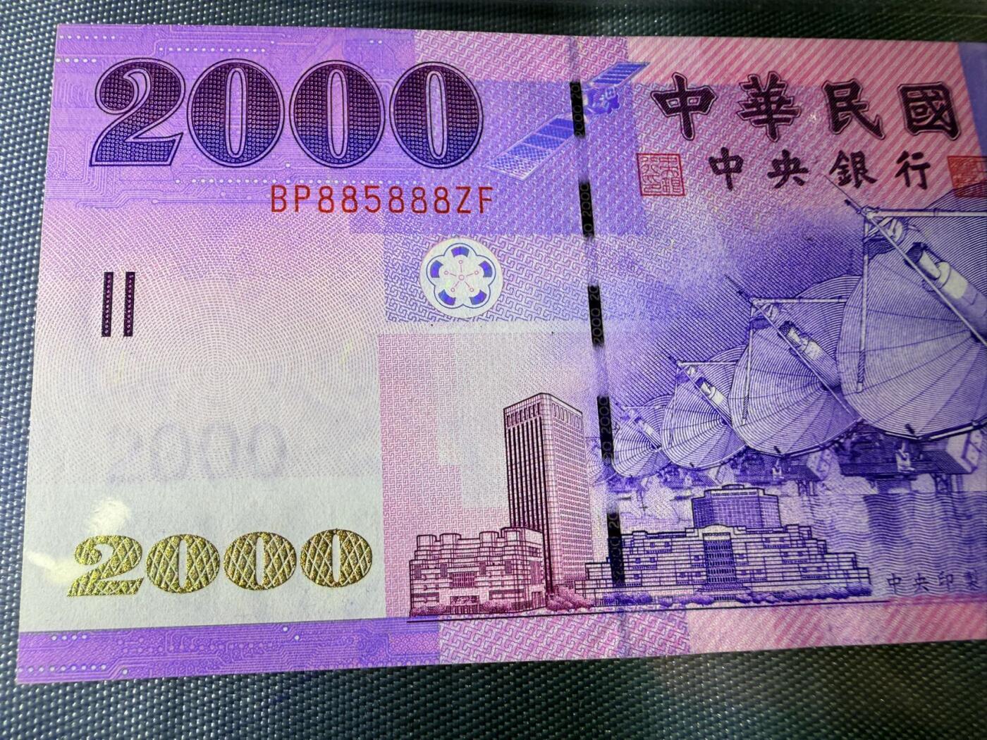 《外钞收藏家》第五百七十一期（国庆场第二场）（本平台长期征集拍品、欢迎藏友们联系合作） 新台币中华民国2000元纸币，全新 UNC 豹子BP885888，正面印有卫星天线和城市建筑图案，背面是雪山和鲑鱼图案，紫色调设计。