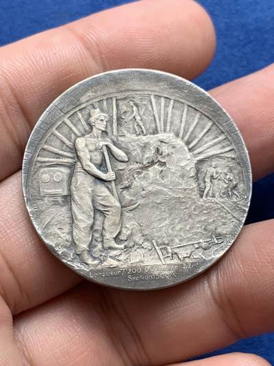 《竞宝斋》第423场 周日，周一，周二  3场连拍 （全场包邮） 法国鲁夫运河工程银质纪念章 22.9克 35.8mm  普通外拍 3200成交 正面：六边形盾徽上刻有年份1775， 图案区域标注1911-1916年及签名“GREGOIRE”；底部铭文“致鲁夫大型海上隧道的合作者与工人们”。背面：正在开凿的隧道中，一名工人倚靠镐头休息；底部铭文“长度7,200米 开口22米/断面300平方米”。 原盒  此章颁发给桥梁与公路总监察长克拉韦耶 