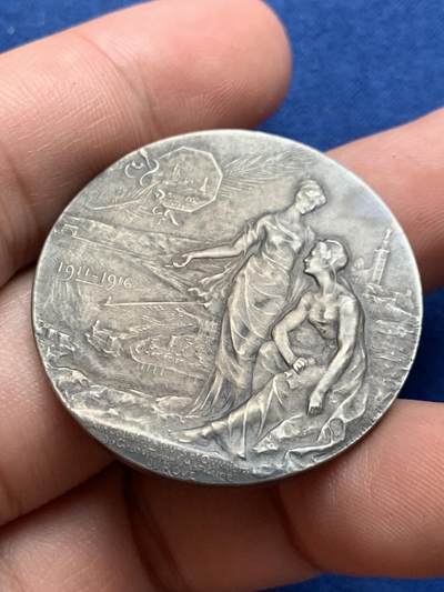 《竞宝斋》第423场 周日，周一，周二  3场连拍 （全场包邮） 法国鲁夫运河工程银质纪念章 22.9克 35.8mm  普通外拍 3200成交 正面：六边形盾徽上刻有年份1775， 图案区域标注1911-1916年及签名“GREGOIRE”；底部铭文“致鲁夫大型海上隧道的合作者与工人们”。背面：正在开凿的隧道中，一名工人倚靠镐头休息；底部铭文“长度7,200米 开口22米/断面300平方米”。 原盒  此章颁发给桥梁与公路总监察长克拉韦耶 