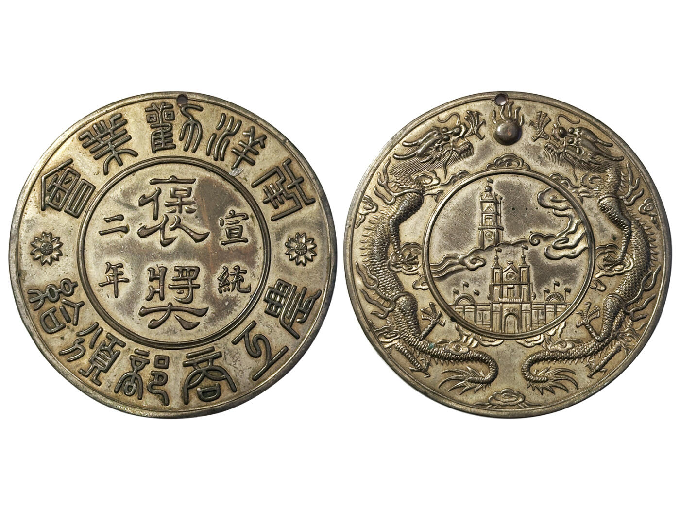 冠军2025年11月29日澳门拍卖 1910年（宣統二年）南洋勸業會農工商部頒給褒獎獎章，正面篆書“宣統二年農工商部頒給南洋勸業會褒獎” 文字，背面未南洋勸業會展覽場館及紀念塔圖，環繞雙龍戲珠圖案，BWS收藏，稀少

南洋勸業會是中國舉辦的第一次世界博覽會，也是中國歷史上首次以官方名義主辦的國際性博覽會。由兩江總督兼南洋大臣端方、江蘇巡撫陳啟泰奏請清政府批准舉辦的，於清宣統二年（1910年）6月5日在南京舉辦，歷時半年，共有30多萬
