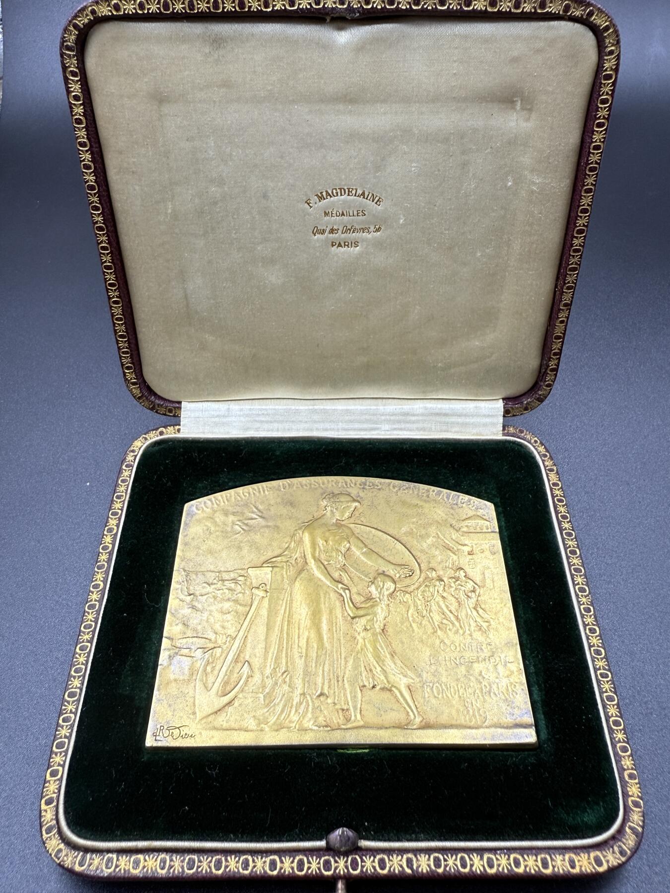 「木头集藏」“双节献礼”——章牌精品专场！ 1920年法国通用保险公司镀金原盒大银章，尺寸：75×65 mm，115 g，边铭：菱形厂标 ARGENT 野猪头银标，正面背景刻画 火灾 与 雷暴天气下海浪吞噬船只的场景，主体刻画女神手持盾牌保护幼童，加上船锚、柱式元素，寓意保险的保障和可靠，奖章授予：Frédéric Chevalie 先生， 1867-1920年间担任该公司金融研究部门主管，少见大银章，精致烫金皮盒，收藏佳品。