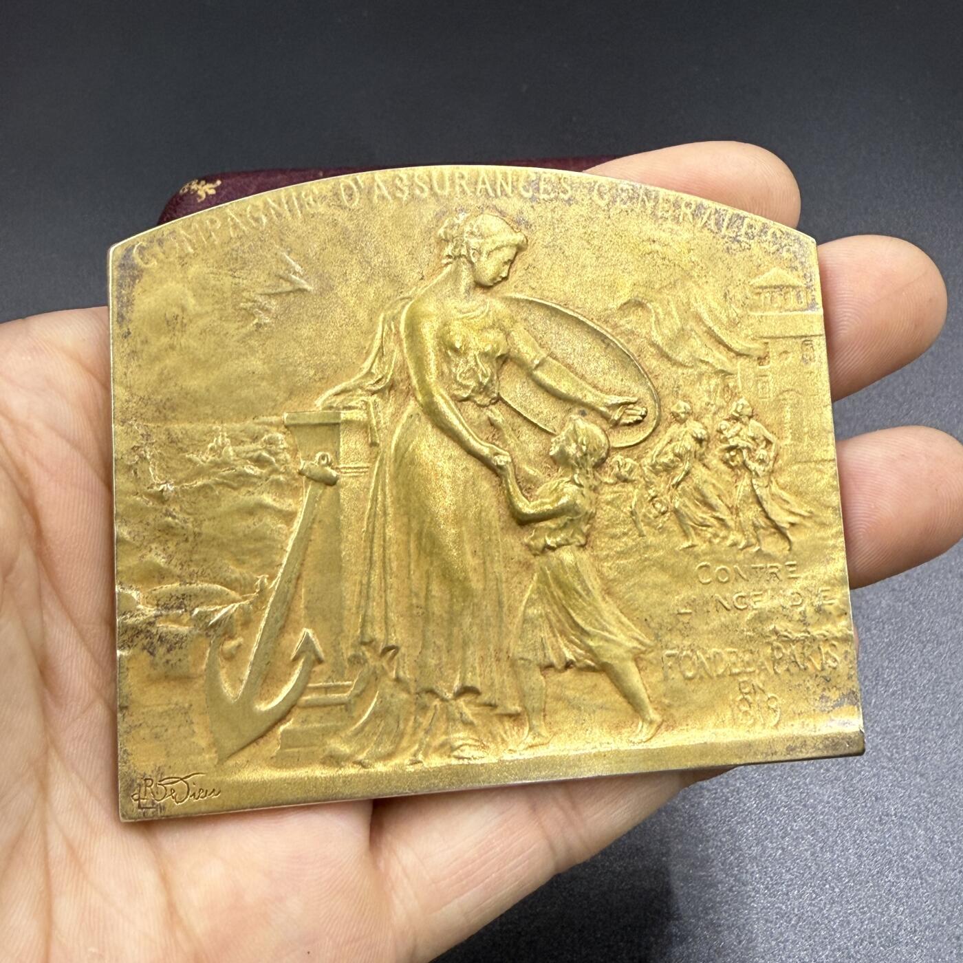 「木头集藏」“双节献礼”——章牌精品专场！ 1920年法国通用保险公司镀金原盒大银章，尺寸：75×65 mm，115 g，边铭：菱形厂标 ARGENT 野猪头银标，正面背景刻画 火灾 与 雷暴天气下海浪吞噬船只的场景，主体刻画女神手持盾牌保护幼童，加上船锚、柱式元素，寓意保险的保障和可靠，奖章授予：Frédéric Chevalie 先生， 1867-1920年间担任该公司金融研究部门主管，少见大银章，精致烫金皮盒，收藏佳品。