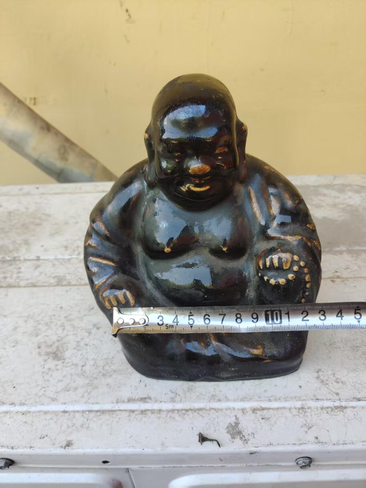 清代黑釉弥勒佛像，釉色厚重凝润，造型饱满生动。尺寸高约18厘米，品相完整，有轻微使用痕迹。黑釉色泽均匀，釉面光亮，适合收藏或摆设