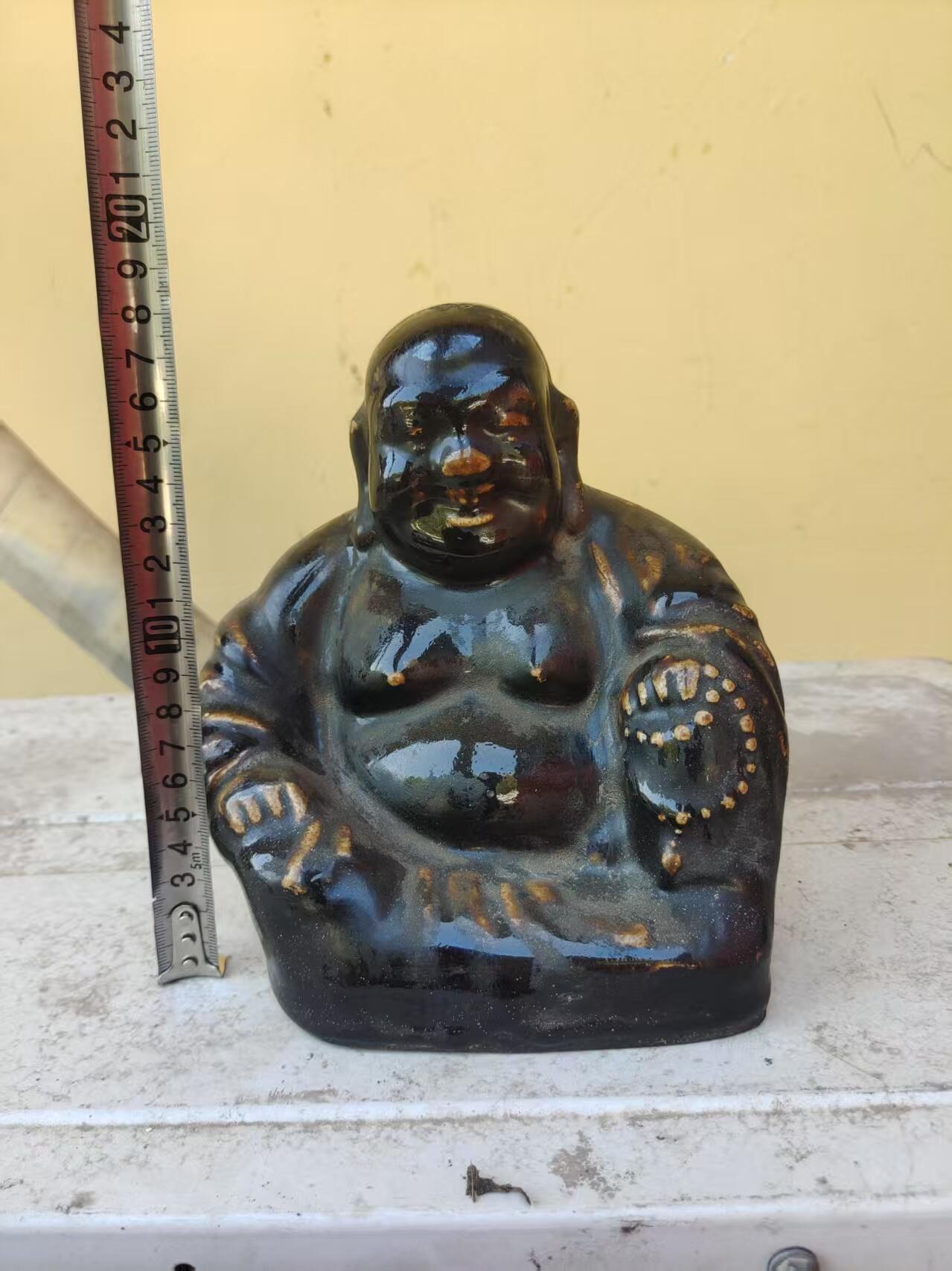清代黑釉弥勒佛像，釉色厚重凝润，造型饱满生动。尺寸高约18厘米，品相完整，有轻微使用痕迹。黑釉色泽均匀，釉面光亮，适合收藏或摆设