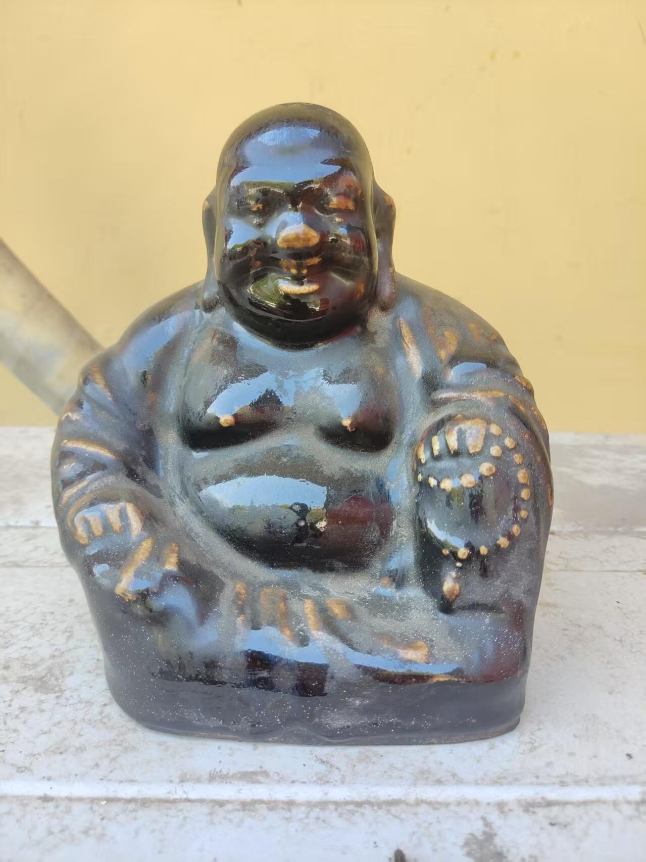 清代黑釉弥勒佛像，釉色厚重凝润，造型饱满生动。尺寸高约18厘米，品相完整，有轻微使用痕迹。黑釉色泽均匀，釉面光亮，适合收藏或摆设