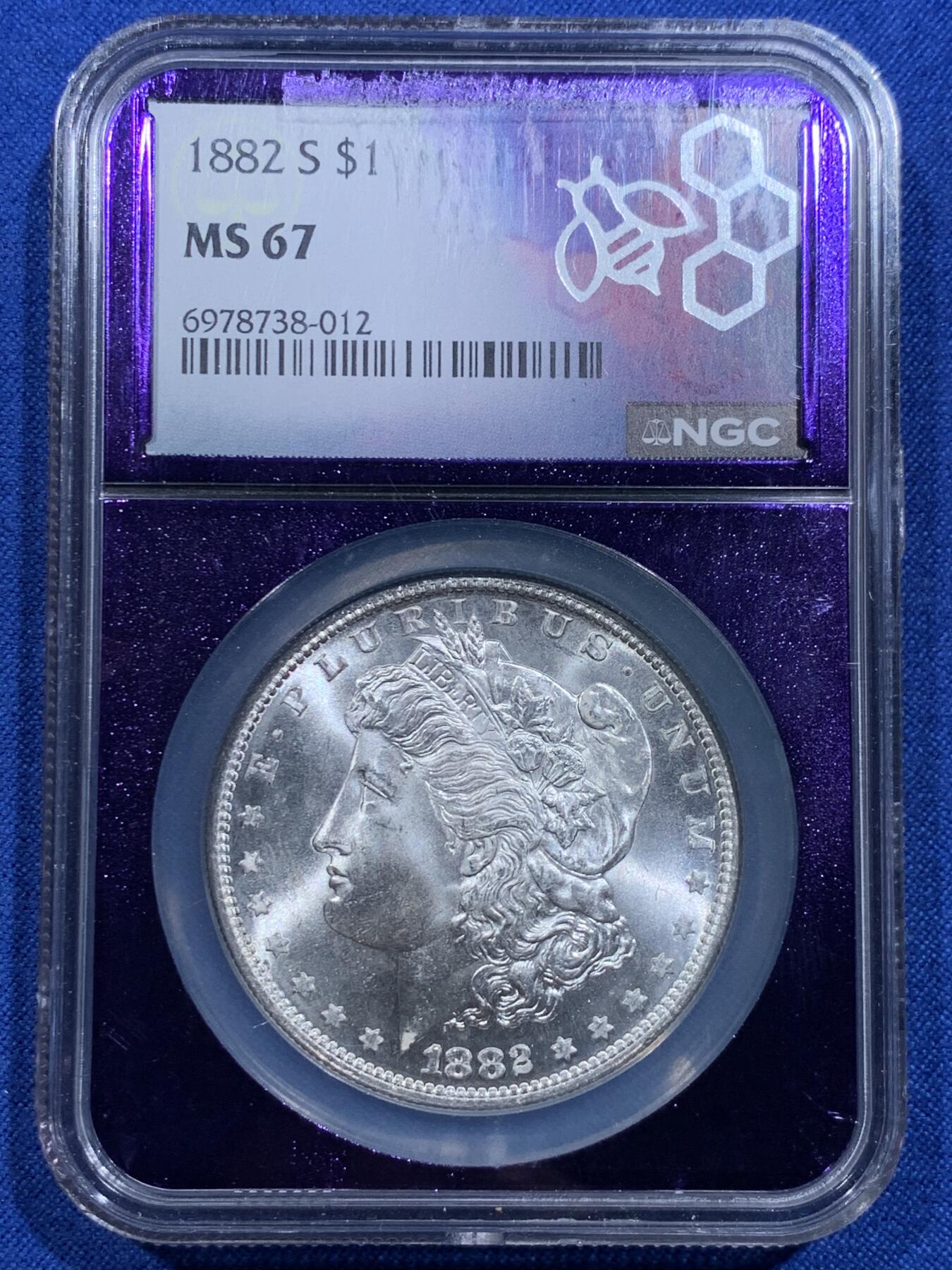 《竞宝斋》第425场 周日，周一  2场连拍 （全场包邮） NGC MS67 美国 1882-S 摩根银币 相当稀有和好看的暗紫色蜜蜂图案评级盒 配上收藏级别的分数 是不可多得的收藏佳品