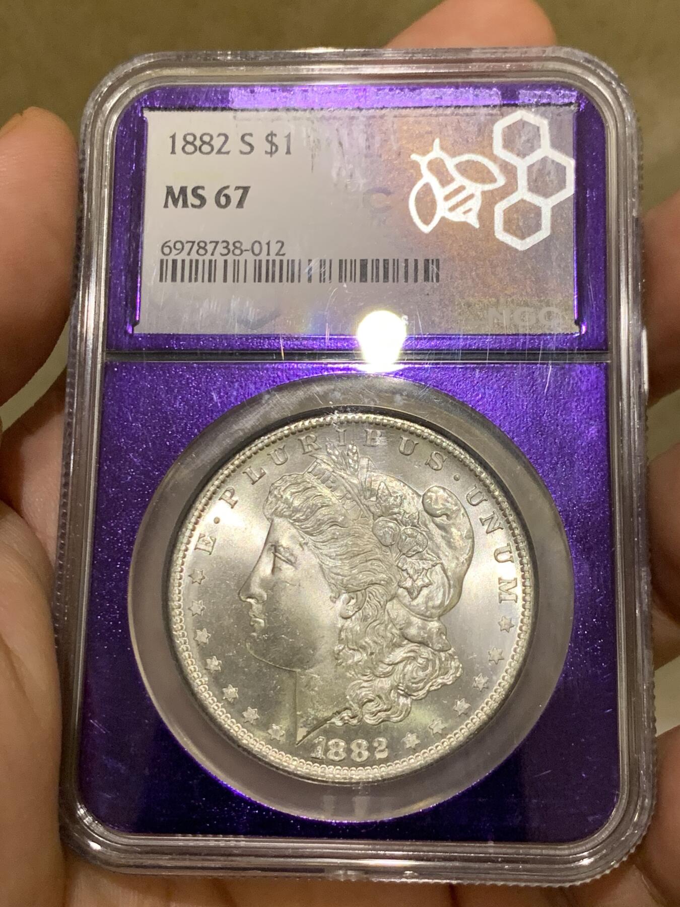 《竞宝斋》第425场 周日，周一  2场连拍 （全场包邮） NGC MS67 美国 1882-S 摩根银币 相当稀有和好看的暗紫色蜜蜂图案评级盒 配上收藏级别的分数 是不可多得的收藏佳品