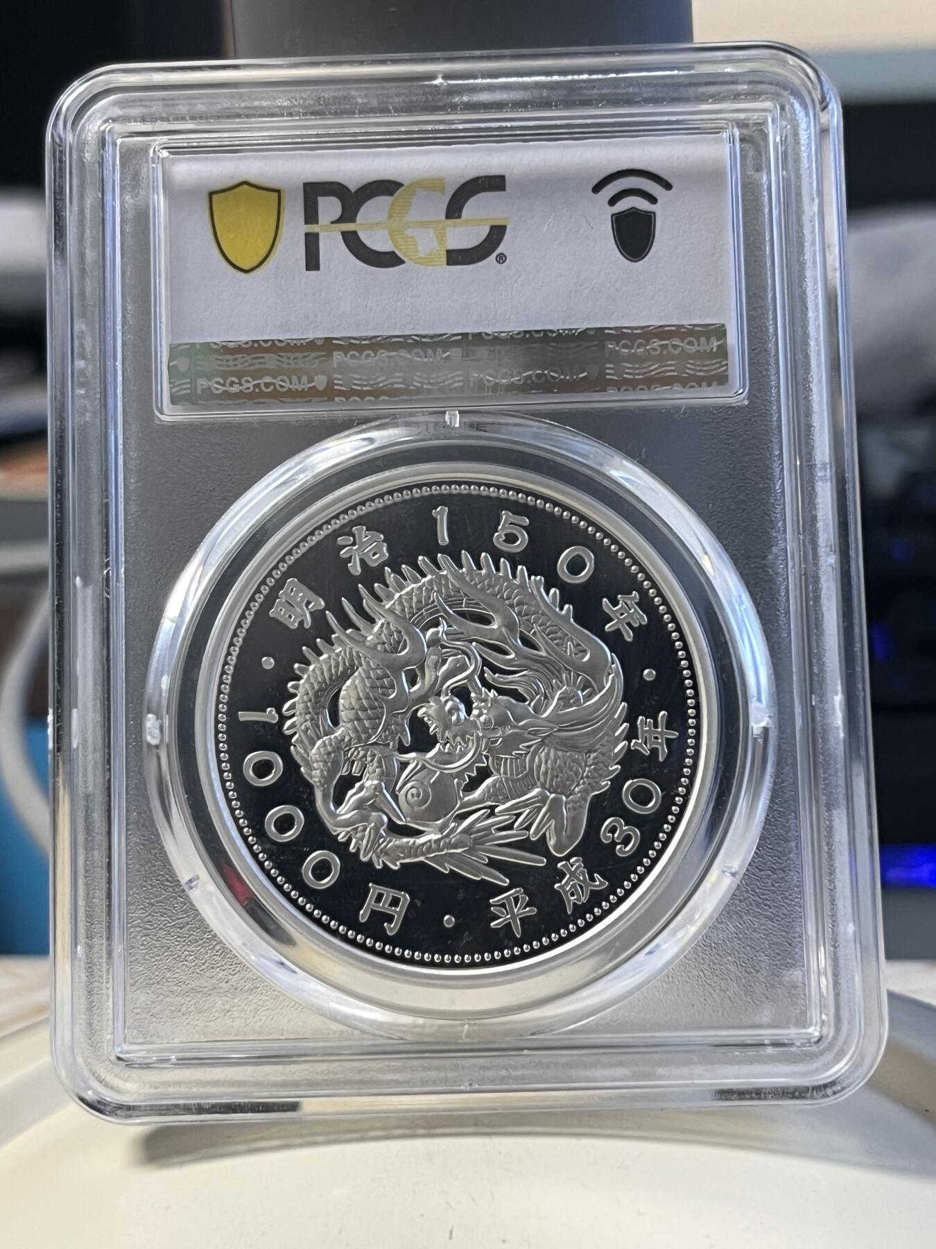 第177期拍卖【长期征集拍品】 PCGS PR70DCAM 2018年发行的日本明治150周年彩银纪念币-1000日元（1盎司克重，999纯银，币径40MM，限量发行5万枚）