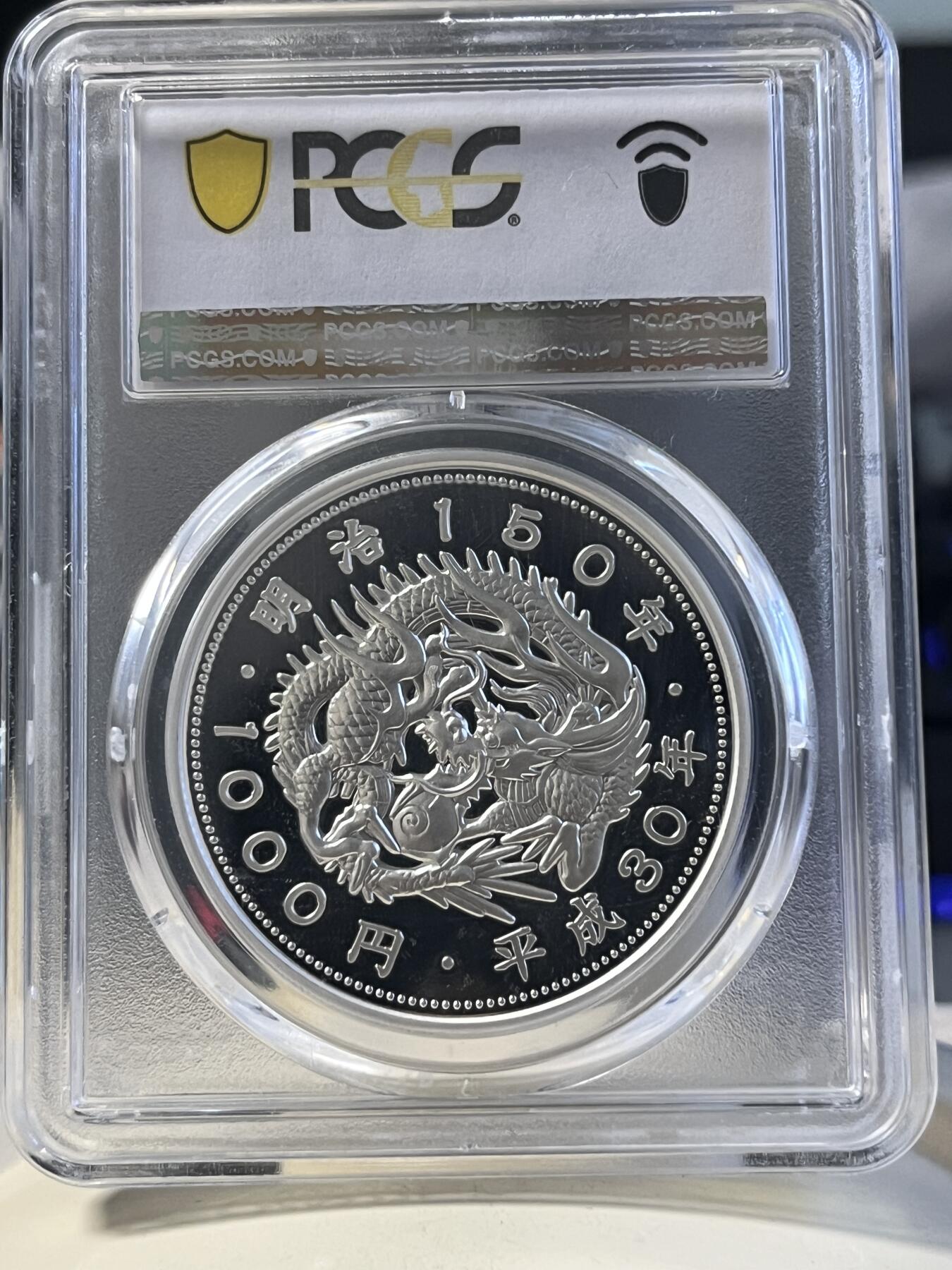 第177期拍卖【长期征集拍品】 PCGS PR70DCAM 2018年发行的日本明治150周年彩银纪念币-1000日元（1盎司克重，999纯银，币径40MM，限量发行5万枚）