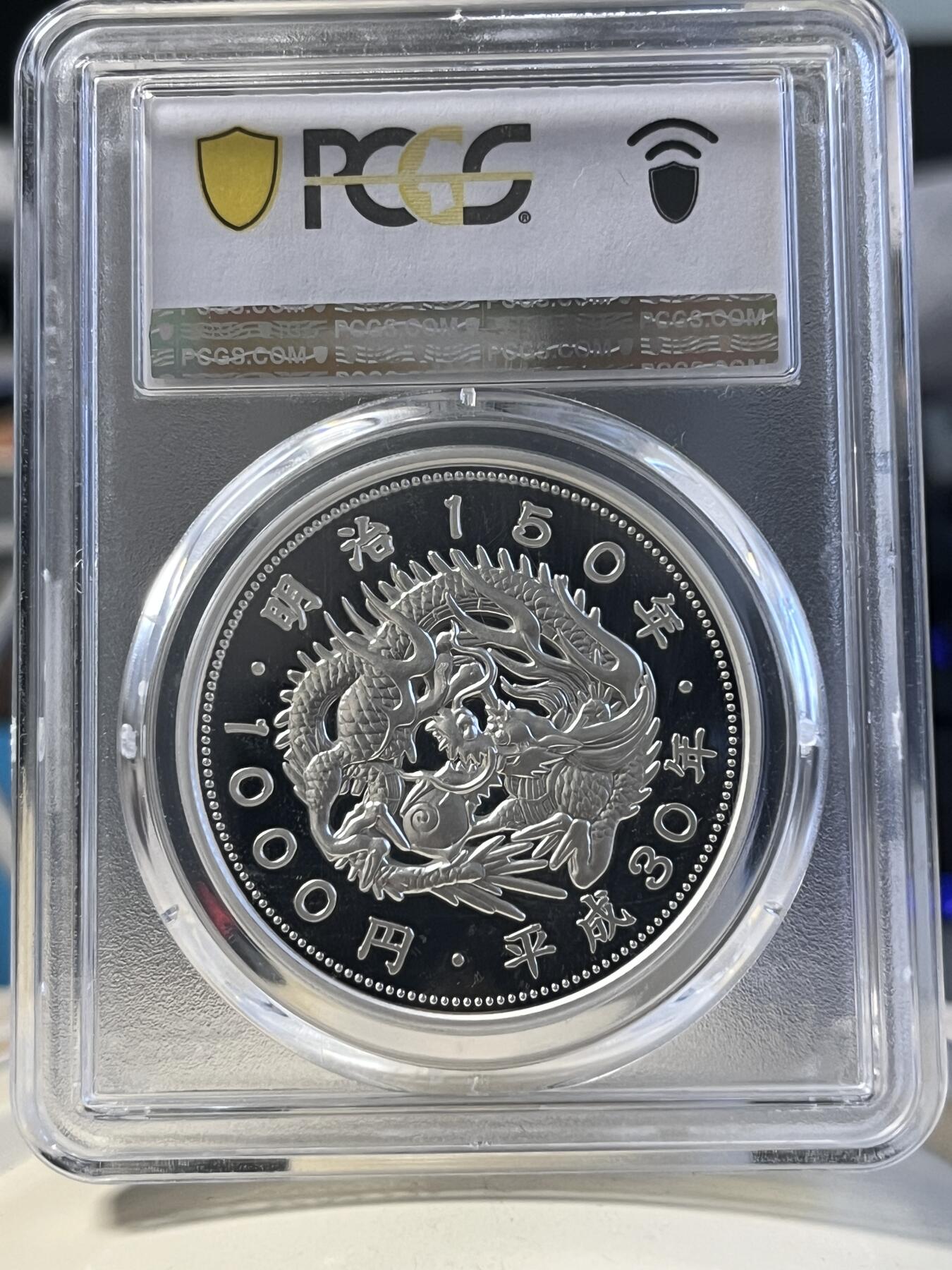 第177期拍卖【长期征集拍品】 PCGS PR70DCAM 2018年发行的日本明治150周年彩银纪念币-1000日元（1盎司克重，999纯银，币径40MM，限量发行5万枚）