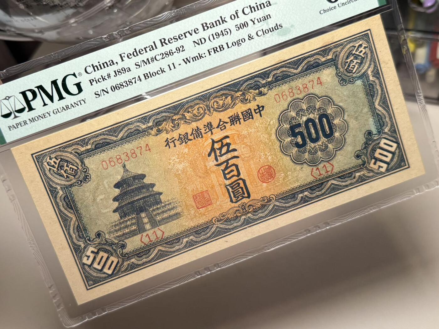 （自动截拍）PMG评级民国纸币专拍第20251012期，全场包邮 【乾奕收藏】出民国34年1945年中国联合准备银行伍百圆，长号码版本，天坛图案，行标+云纹水印，美国PMG63E，此品种因纸张原因很难带E