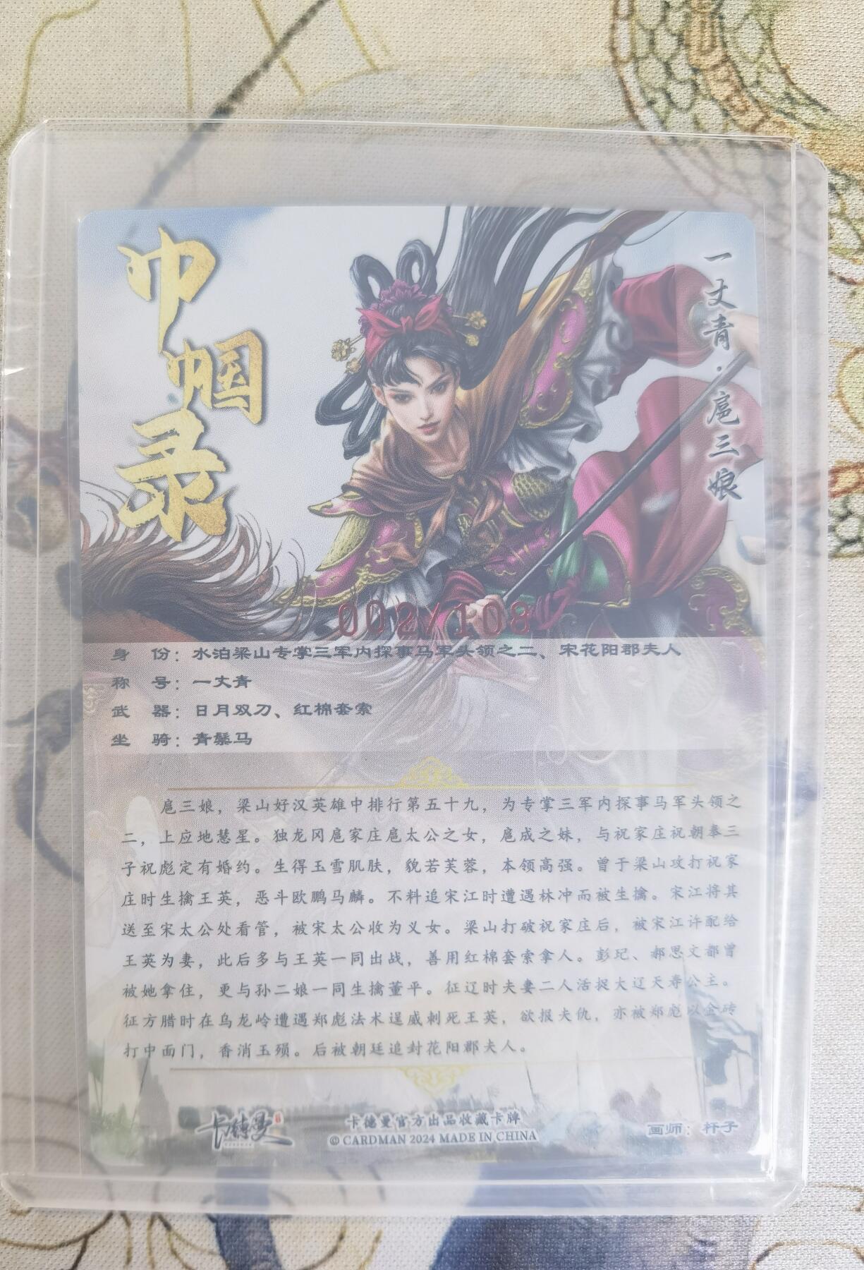 奇趣收藏卡牌拍卖第24场 【亲签卡】卡德曼 巾帼录 杆子 绘 一丈青扈三娘 紫衣 亲签粗闪1张  编号002/108，全新覆膜卡夹卡膜保护