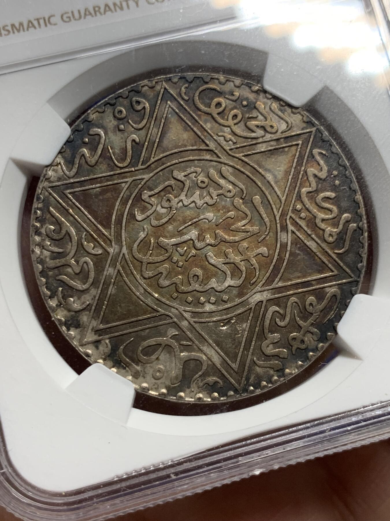 《竞宝斋》第428场 周日，周一  2场连拍 （全场包邮） NGC UNCD 摩洛哥AH1299（1882年）10迪拉姆银币，稀有版别仅次于AH1313，味道币味道足，五彩包浆锋利感十足，状态极佳。疑似错杀。