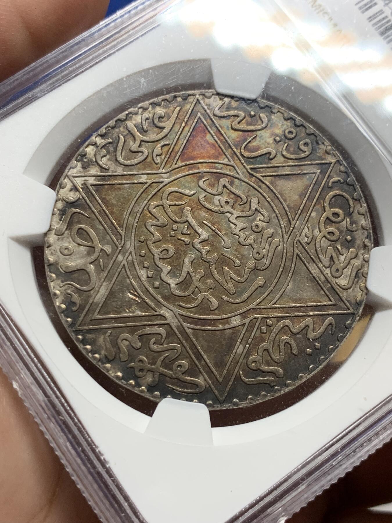 《竞宝斋》第428场 周日，周一  2场连拍 （全场包邮） NGC UNCD 摩洛哥AH1299（1882年）10迪拉姆银币，稀有版别仅次于AH1313，味道币味道足，五彩包浆锋利感十足，状态极佳。疑似错杀。