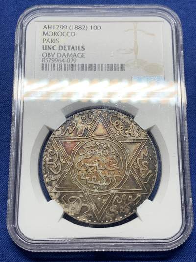 《竞宝斋》第428场 周日，周一  2场连拍 （全场包邮） - NGC UNCD 摩洛哥AH1299（1882年）10迪拉姆银币，稀有版别仅次于AH1313，味道币味道足，五彩包浆锋利感十足，状态极佳。疑似错杀。