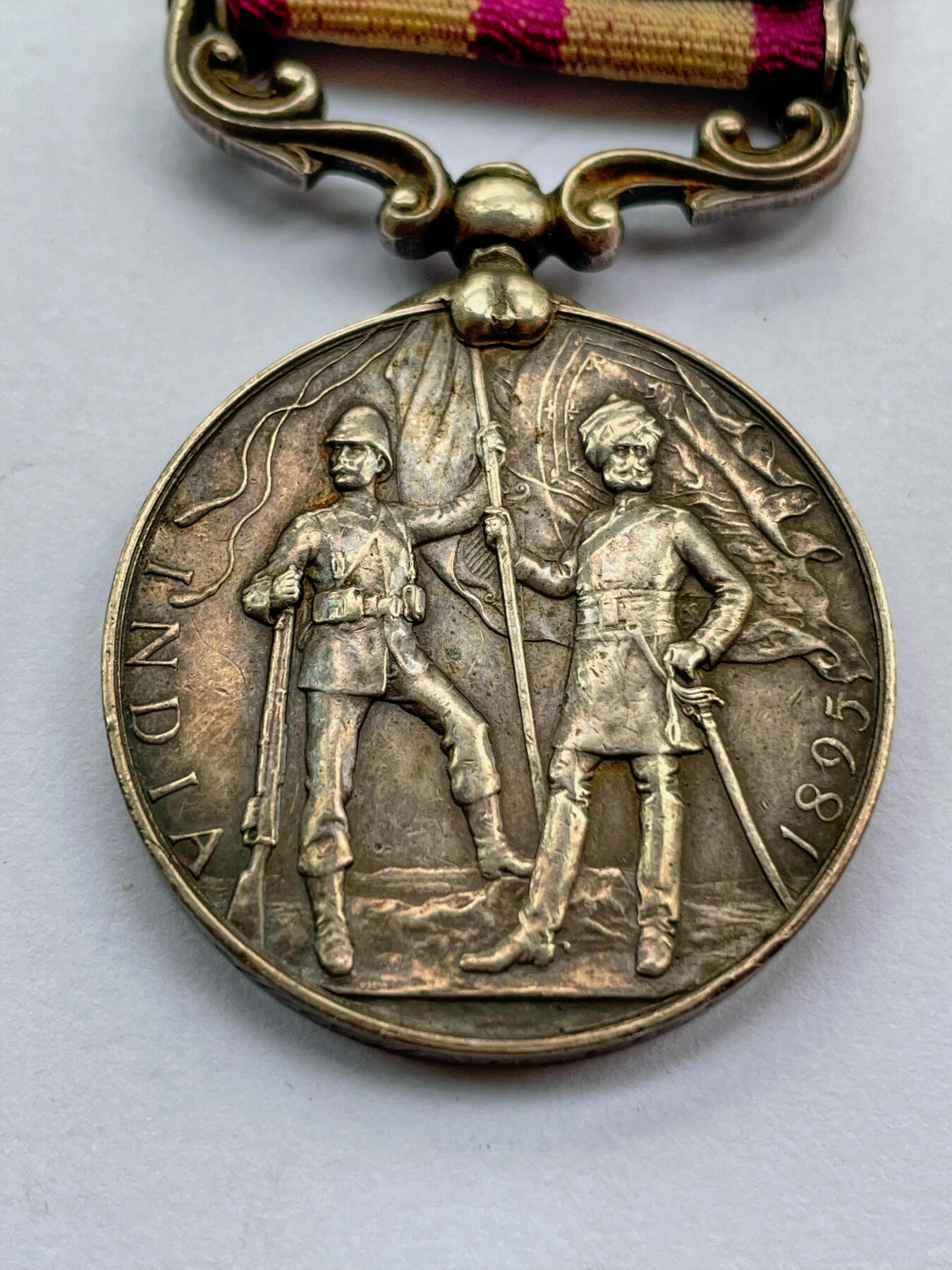 盛世勋华——号角文化勋章邮票专场拍卖第284期 英国印度服役奖章（1895-1902版）银制 维多利亚女王版 少见带双条（旁遮普前线/瓦济里斯坦条）带刻名 授予在英属印度西北镇压当地部族叛乱的英印军 英国前首相丘吉尔1896年在印度服役也参与了该战争，获得了带旁遮普前线条的印度服役奖章 见图