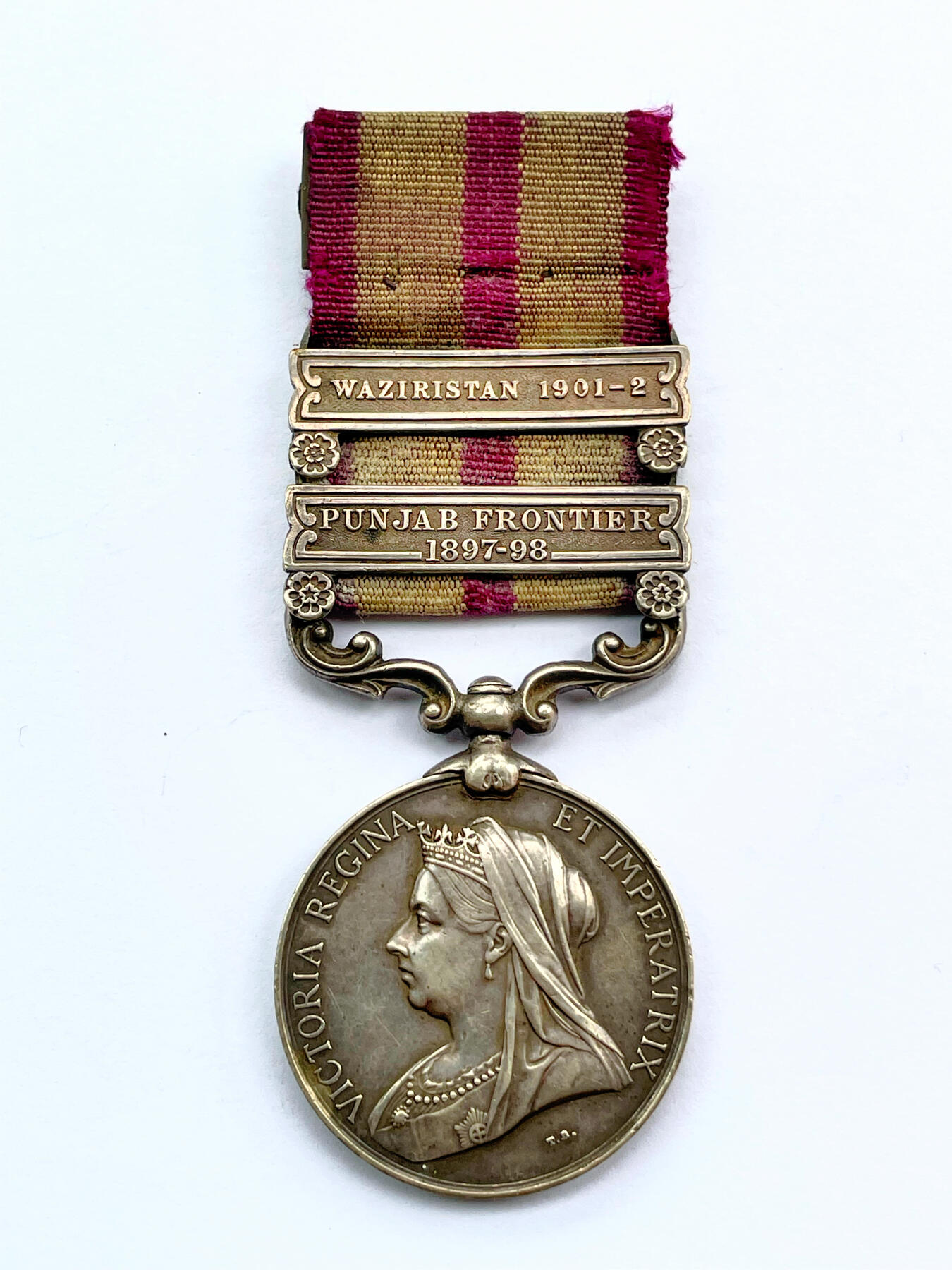 盛世勋华——号角文化勋章邮票专场拍卖第284期 英国印度服役奖章（1895-1902版）银制 维多利亚女王版 少见带双条（旁遮普前线/瓦济里斯坦条）带刻名 授予在英属印度西北镇压当地部族叛乱的英印军 英国前首相丘吉尔1896年在印度服役也参与了该战争，获得了带旁遮普前线条的印度服役奖章 见图
