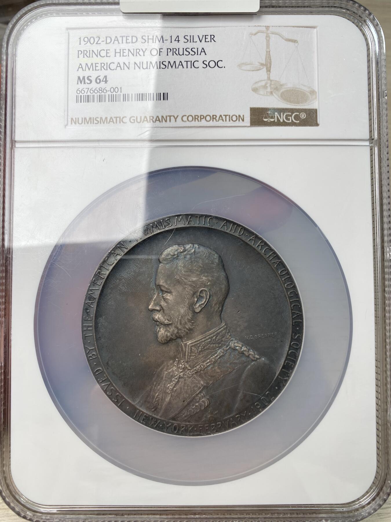 万国钱币拍卖第053期【万国秋季大拍上●周五周六两场连拍】 NGC MS64 1902年德国普鲁士王子亨利出访美国纪念大银章 原味天鹅绒包浆，正面为身穿戎装的普鲁士王子，背面为代表商业繁荣的墨丘利身处云层中看向西方。在背面的右下角还有代表美国的盾徽和普鲁士的鹰徽连在一起。不管是王子人像面还是墨丘利面都雕刻的极其精美，铸造量仅301枚，此枚为唯一入盒记录。69.8MM 143G
